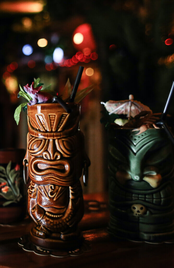 A tiki glass in a tropical bar at night.